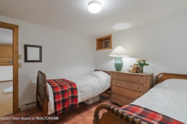 4821 S 2000 E, Victor, ID 83455 - bedroom with baseboard heating, tile patterned floors, and a textured ceiling