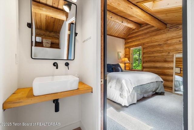 6250 W Paintbrush Trl, Wilson, WY 83014 - bedroom with rustic walls, wooden ceiling, a skylight, and carpet