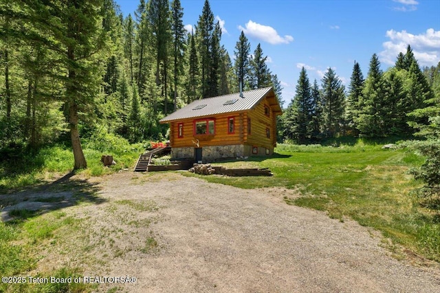 6250 W Paintbrush Trl, Wilson, WY 83014 - view of front of house with log siding, a forest view, stone siding, and a metal roof