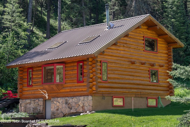 6250 W Paintbrush Trl, Wilson, WY 83014 - view of property exterior featuring log exterior, a standing seam roof, a view of trees, and a metal roof