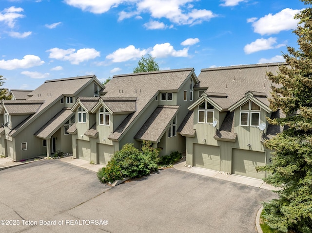 910 Powder Valley Rd Unit 20, Driggs, ID 83422 - view of front facade with an attached garage, driveway, roof with shingles, and a residential view