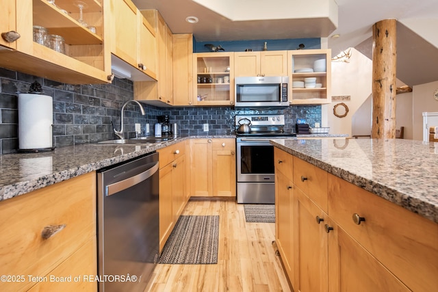 910 Powder Valley Rd Unit 20, Driggs, ID 83422 - kitchen with appliances with stainless steel finishes, light wood finished floors, stone counters, backsplash, and glass insert cabinets