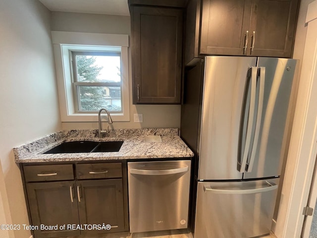 140 Homestead Rd Unit 508, Victor, ID 83455 - kitchen featuring appliances with stainless steel finishes, dark brown cabinetry, and light stone countertops
