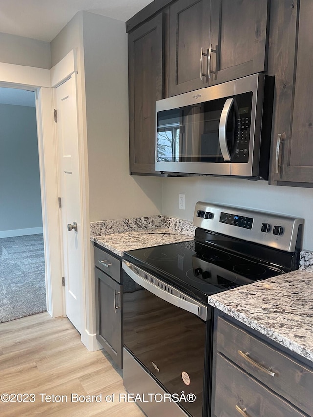 140 Homestead Rd Unit 508, Victor, ID 83455 - kitchen with appliances with stainless steel finishes, light wood-type flooring, light stone countertops, and dark brown cabinetry