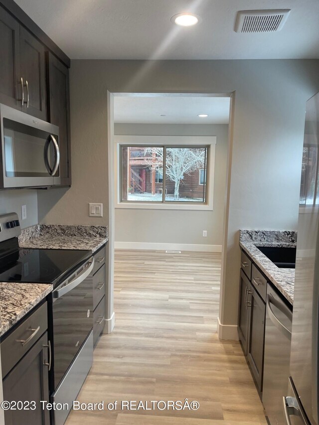140 Homestead Rd Unit 508, Victor, ID 83455 - kitchen with stainless steel appliances, light wood finished floors, and light stone countertops