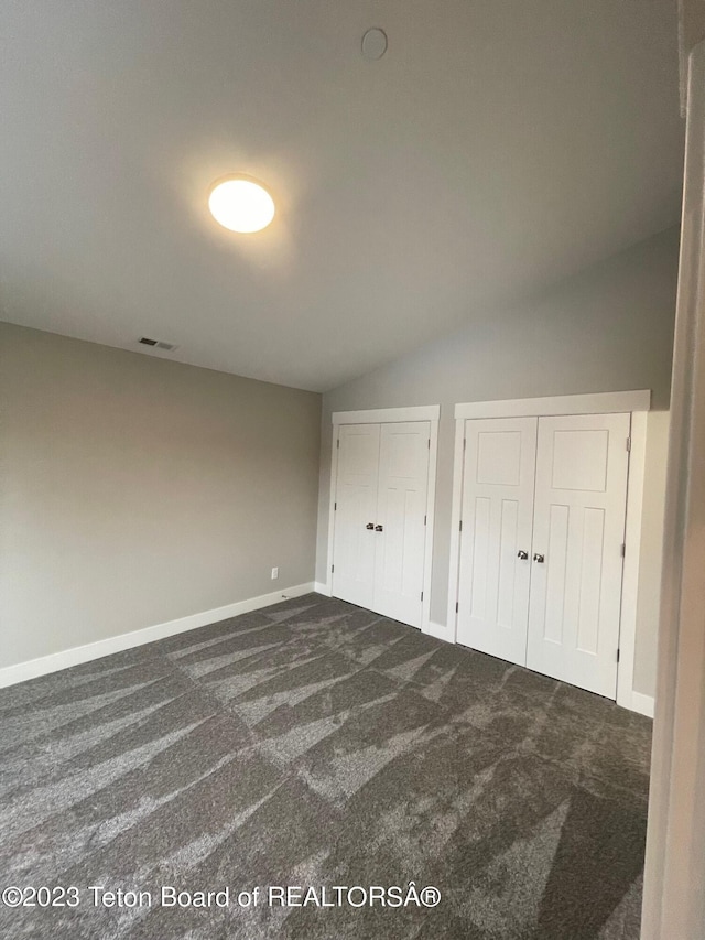 140 Homestead Rd Unit 508, Victor, ID 83455 - unfurnished bedroom with multiple closets, dark colored carpet, and lofted ceiling