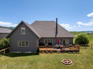 92 Ashley Dr, Alpine, WY 83128 - rear view of property with a fenced backyard, a deck, and an outdoor fire pit