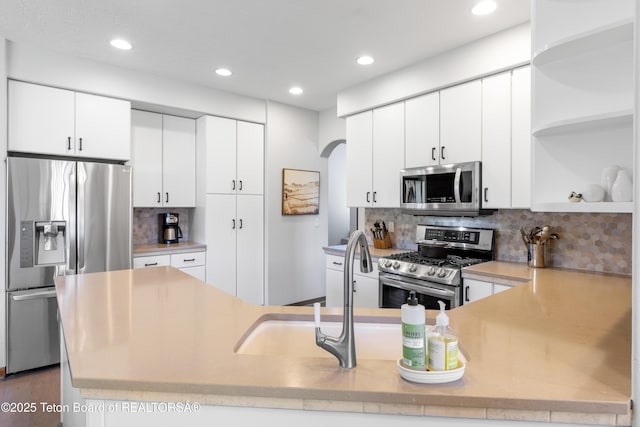 92 Ashley Dr, Alpine, WY 83128 - kitchen with appliances with stainless steel finishes, open shelves, arched walkways, recessed lighting, and tasteful backsplash