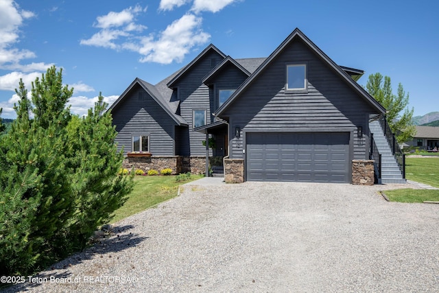 92 Ashley Dr, Alpine, WY 83128 - view of front of home with driveway, stone siding, and stairway