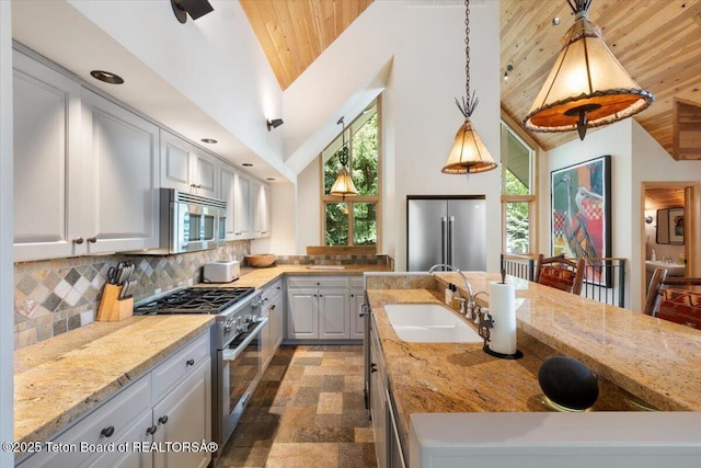 2620 N Fairways Pl W, Wilson, WY 83014 - kitchen featuring appliances with stainless steel finishes, wood ceiling, light stone counters, high vaulted ceiling, and decorative backsplash