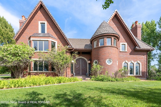 4976 S 49th, Idaho Falls, ID 83406 - tudor-style house featuring a chimney, a front yard, and brick siding