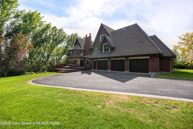 4976 S 49th, Idaho Falls, ID 83406 - view of front of property featuring asphalt driveway, brick siding, a front yard, and a wooden deck