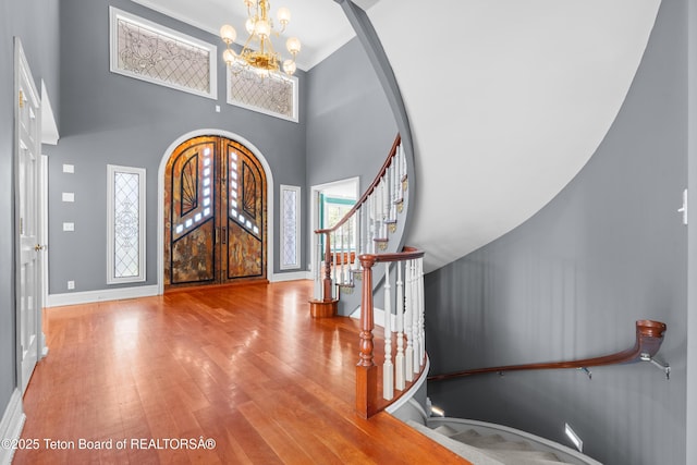 4976 S 49th, Idaho Falls, ID 83406 - entryway with a chandelier, stairway, wood finished floors, arched walkways, and a towering ceiling
