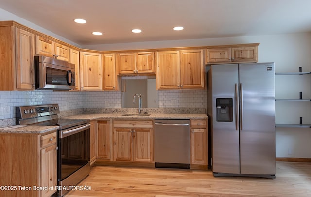 55 Virginian Ln Unit 55-2, Jackson, WY 83002 - kitchen featuring stainless steel appliances, light stone countertops, light wood finished floors, backsplash, and recessed lighting