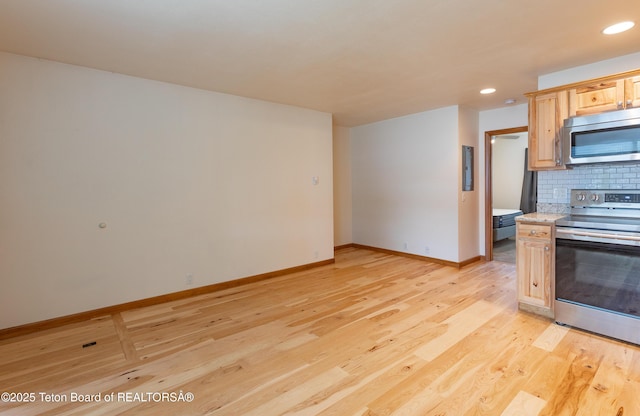 55 Virginian Ln Unit 55-2, Jackson, WY 83002 - kitchen with stainless steel appliances, light wood-style flooring, light countertops, tasteful backsplash, and recessed lighting