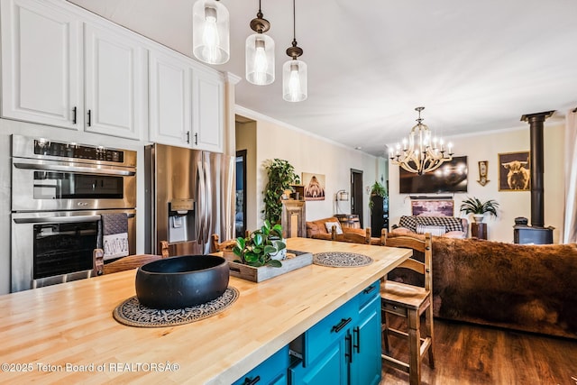 26 Merrimac Trl, Boulder, WY 82923 - kitchen with appliances with stainless steel finishes, butcher block counters, blue cabinets, open floor plan, and white cabinets