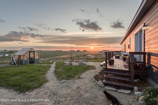26 Merrimac Trl, Boulder, WY 82923 - yard at dusk featuring a greenhouse, a wooden deck, and an outbuilding