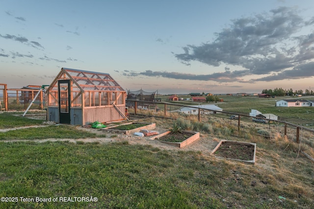 26 Merrimac Trl, Boulder, WY 82923 - yard at dusk featuring a greenhouse, a vegetable garden, and an outdoor structure