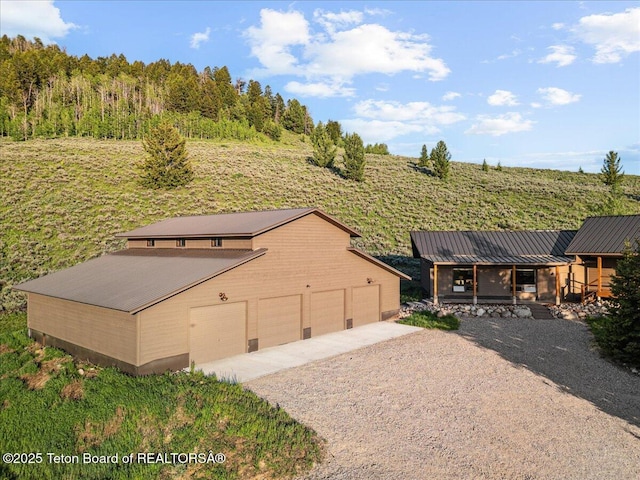 20 Trail Ride Ln, Cora, WY 82925 - view of front of house featuring driveway, an outdoor structure, a metal roof, and a detached garage