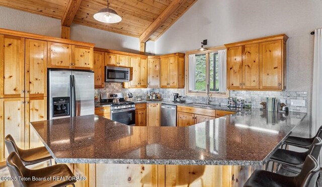 20 Trail Ride Ln, Cora, WY 82925 - kitchen featuring stainless steel appliances, tasteful backsplash, a peninsula, a kitchen bar, and a wood ceiling with exposed beams