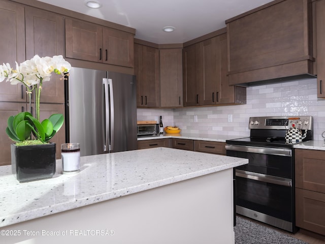 112 Aspen Meadows Rd Unit 36, Driggs, ID 83422 - kitchen featuring stainless steel appliances, backsplash, light stone countertops, and dark brown cabinetry