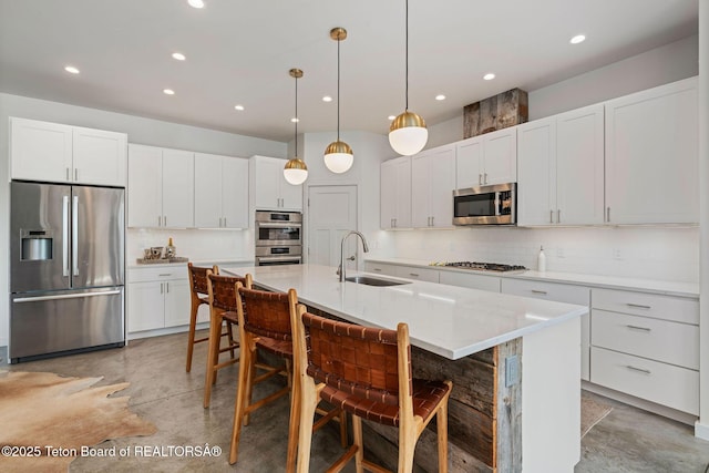 4345 Melody Ranch Dr, Jackson, WY 83001 - kitchen featuring stainless steel appliances, concrete flooring, tasteful backsplash, recessed lighting, and a center island with sink