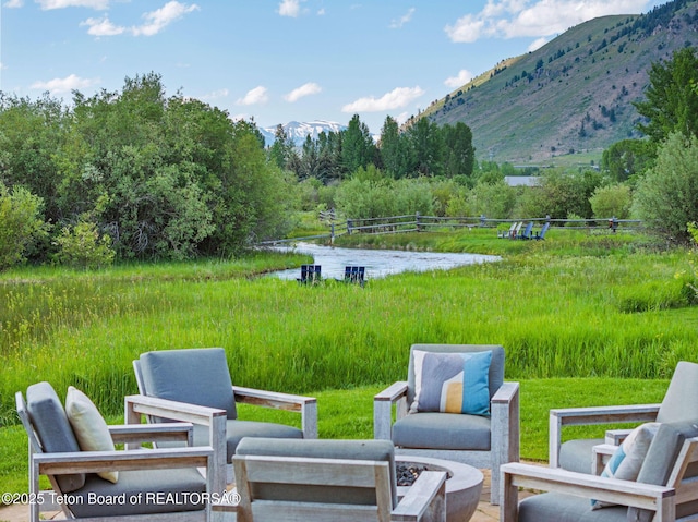 4345 Melody Ranch Dr, Jackson, WY 83001 - view of patio / terrace with a water and mountain view, an outdoor fire pit, and a view of trees