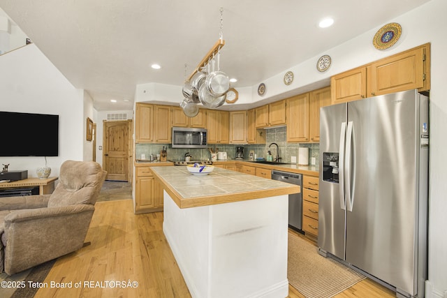 536 Shadow Brook Ln, Driggs, ID 83422 - kitchen featuring stainless steel appliances, tile countertops, open floor plan, a center island, and light wood-style floors