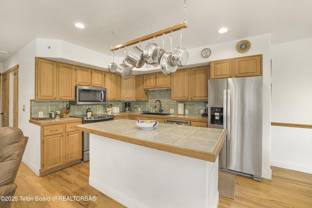 536 Shadow Brook Ln, Driggs, ID 83422 - kitchen with appliances with stainless steel finishes, tile countertops, light wood finished floors, a kitchen island, and recessed lighting