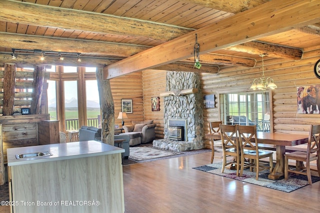 3525 W 13000 N, Felt, ID 83424 - dining room with rustic walls, a wooden ceiling with exposed beams, wood finished floors, a stone fireplace, and a chandelier