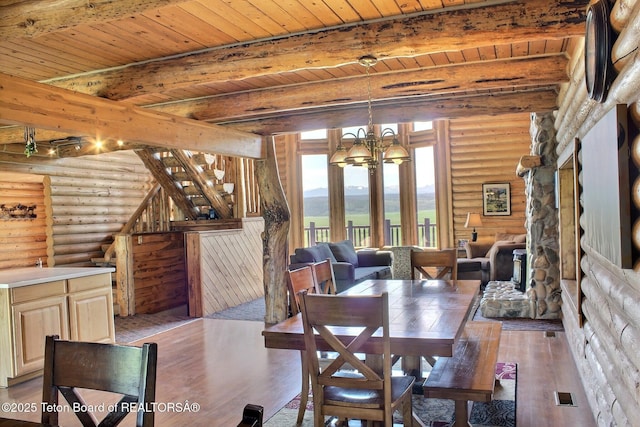 3525 W 13000 N, Felt, ID 83424 - dining space with log walls, wood-type flooring, a wood ceiling with exposed beams, a chandelier, and stairs