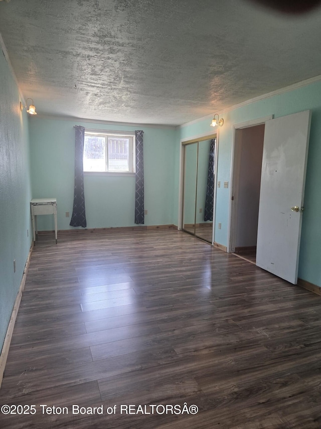 321 Smith Ave, Big Piney, WY 83113 - unfurnished bedroom featuring wood finished floors, a textured ceiling, and a closet