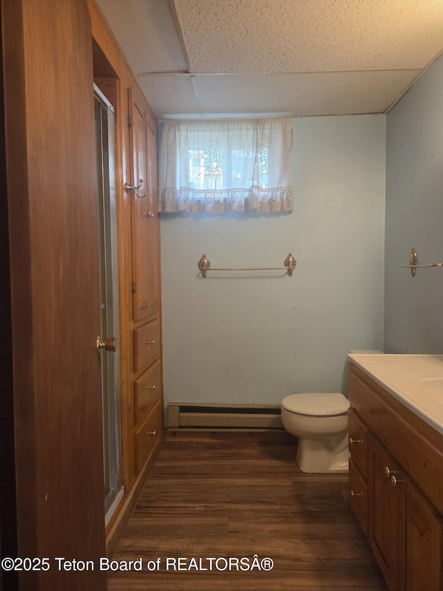 321 Smith Ave, Big Piney, WY 83113 - bathroom with a baseboard heating unit, wood finished floors, vanity, and a shower stall