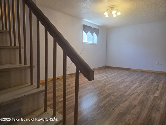 321 Smith Ave, Big Piney, WY 83113 - basement featuring wood finished floors, a textured ceiling, and stairs