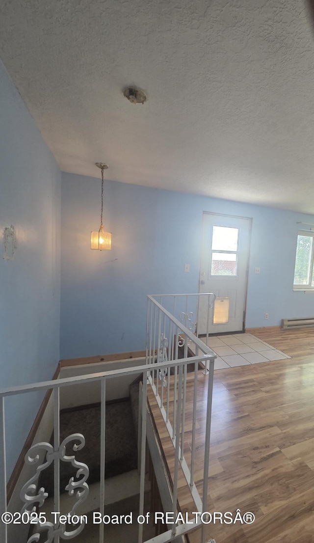321 Smith Ave, Big Piney, WY 83113 - staircase with a baseboard radiator, wood finished floors, and a textured ceiling