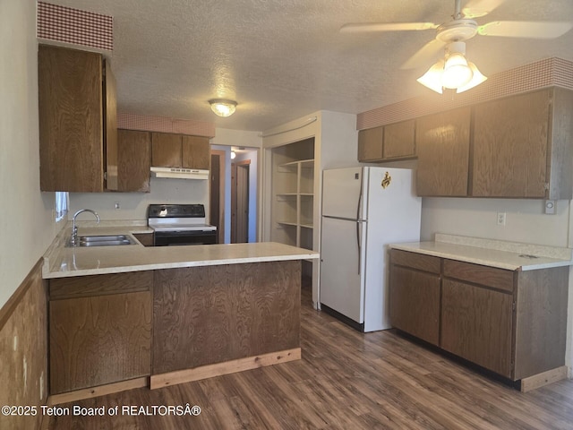 321 Smith Ave, Big Piney, WY 83113 - kitchen with electric stove, under cabinet range hood, freestanding refrigerator, a peninsula, and dark wood-style floors