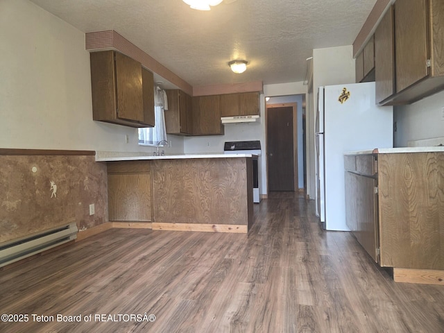 321 Smith Ave, Big Piney, WY 83113 - kitchen with range, under cabinet range hood, freestanding refrigerator, a peninsula, and light countertops