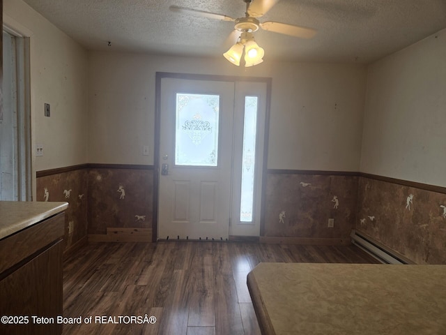 321 Smith Ave, Big Piney, WY 83113 - foyer with a baseboard radiator, a textured ceiling, wood finished floors, a wainscoted wall, and ceiling fan
