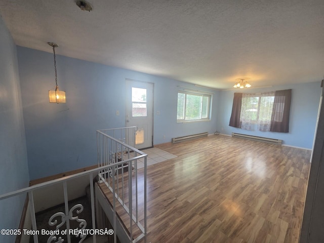 321 Smith Ave, Big Piney, WY 83113 - spare room featuring a baseboard radiator, wood finished floors, and a textured ceiling
