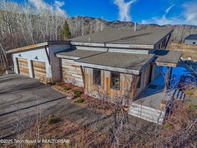 9632 Little Pine Ln, Victor, ID 83455 - view of side of home featuring a shingled roof, asphalt driveway, and a mountain view