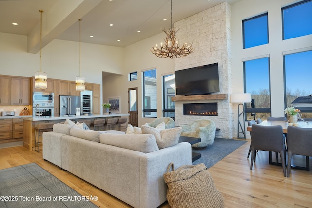 9632 Little Pine Ln, Victor, ID 83455 - living room featuring a high ceiling, a chandelier, a stone fireplace, light wood-style floors, and recessed lighting