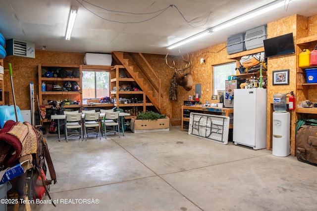 939 W Stuart St, Pinedale, WY 82941 - garage featuring a heating unit, freestanding refrigerator, and a workshop area