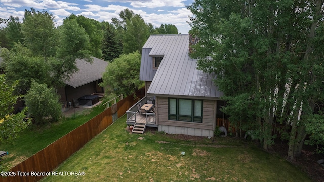 939 W Stuart St, Pinedale, WY 82941 - view of side of home featuring a deck, a standing seam roof, a fenced backyard, and a metal roof
