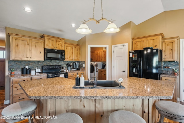 3 Healers, Pinedale, WY 82941 - kitchen with black appliances, lofted ceiling, backsplash, a breakfast bar area, and a large island with sink