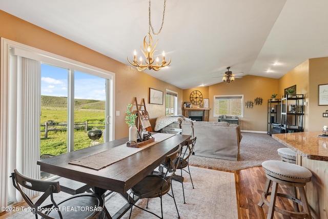 3 Healers, Pinedale, WY 82941 - dining area with wood finished floors, a ceiling fan, a chandelier, vaulted ceiling, and a fireplace