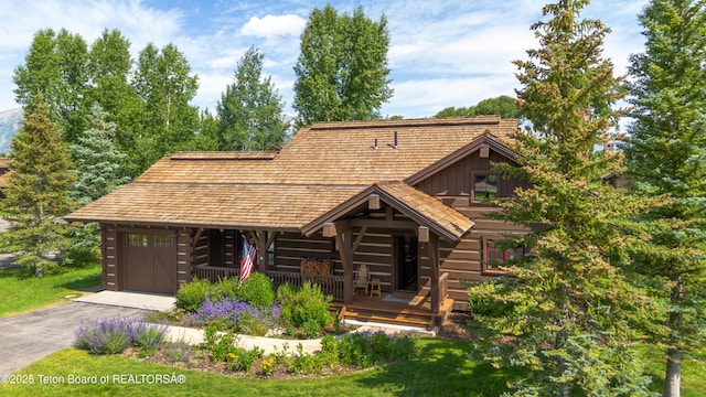 5862 N Coneflower Dr Unit 17, Jackson, WY 83001 - log cabin featuring a porch, driveway, log siding, board and batten siding, and a front yard