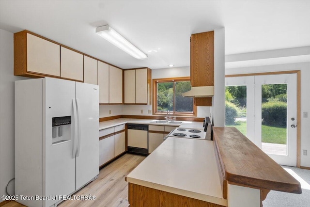 816 Powderhorn Ln Unit 816D, Jackson, WY 83001 - kitchen with white appliances, under cabinet range hood, light wood-type flooring, and light countertops
