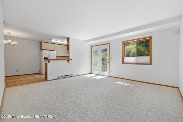 816 Powderhorn Ln Unit 816D, Jackson, WY 83001 - unfurnished living room with a baseboard heating unit, a chandelier, and light colored carpet