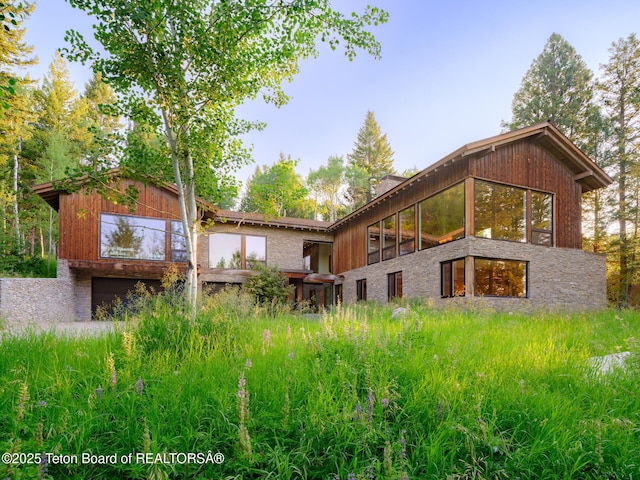 7970 N Granite Ridge Rd, Teton Village, WY 83025 - rear view of house featuring an attached garage and a chimney