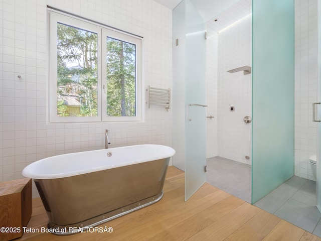 7970 N Granite Ridge Rd, Teton Village, WY 83025 - bathroom with tile walls, a soaking tub, wood finished floors, and a walk in shower